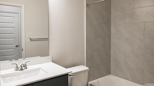 full bathroom featuring tiled shower / bath combo, vanity, and toilet