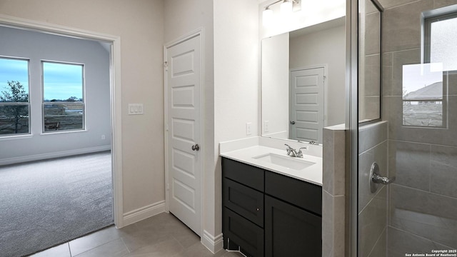 bathroom featuring tile patterned flooring, vanity, a healthy amount of sunlight, and a shower with shower door