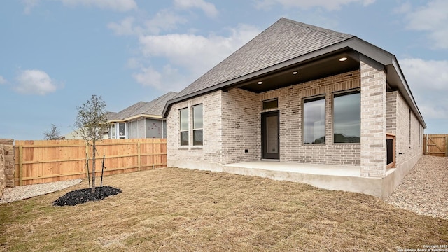 back of property featuring a patio and a lawn