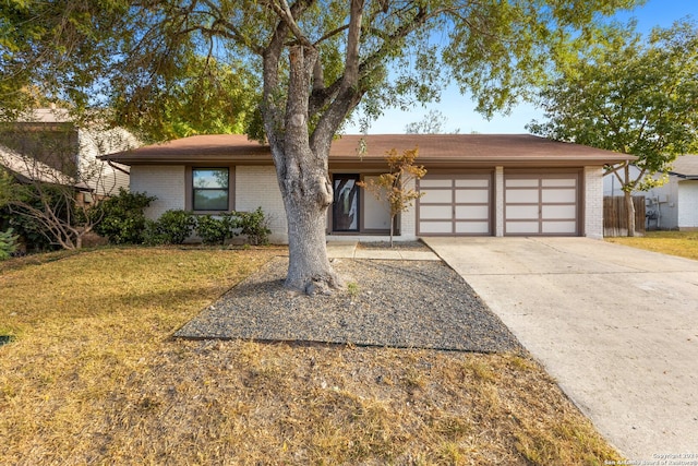 ranch-style home featuring a garage and a front lawn