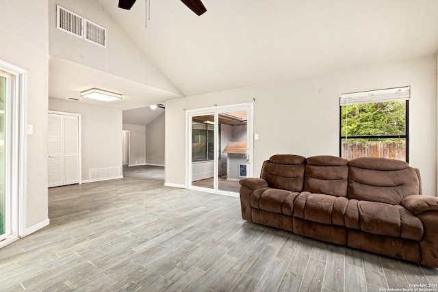 living room featuring ceiling fan, high vaulted ceiling, and light wood-type flooring