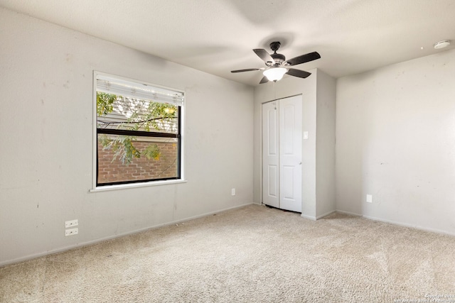 unfurnished bedroom with a closet, carpet flooring, and ceiling fan