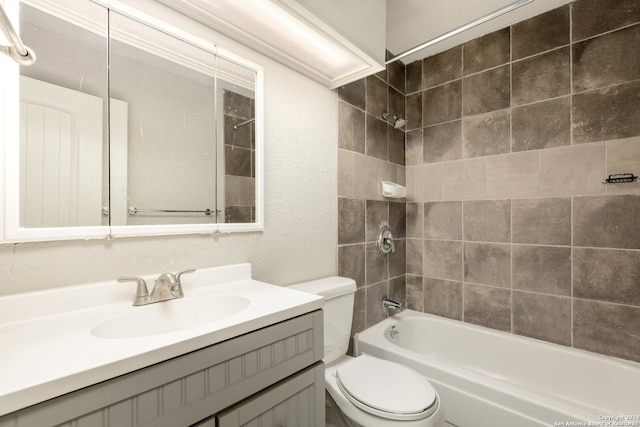 full bathroom with tiled shower / bath, vanity, and toilet