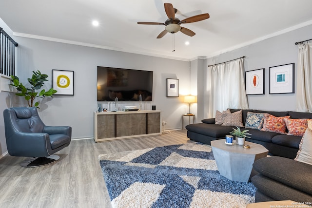 living room with crown molding, wood-type flooring, and ceiling fan