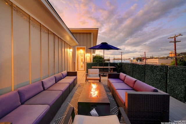 patio terrace at dusk with an outdoor living space with a fire pit