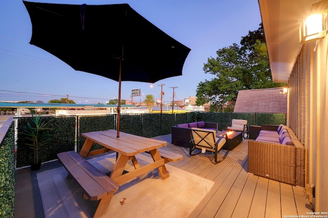 deck at dusk featuring an outdoor living space