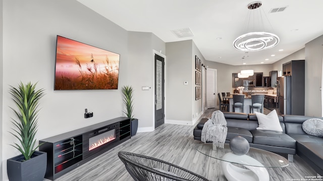 living room with a chandelier and light hardwood / wood-style flooring