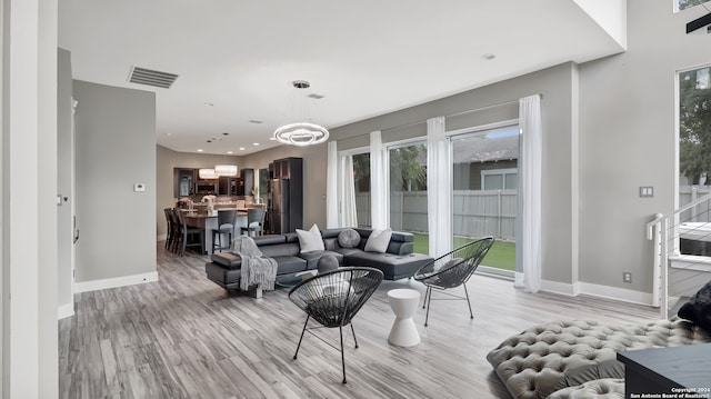 living room with a chandelier and light hardwood / wood-style flooring