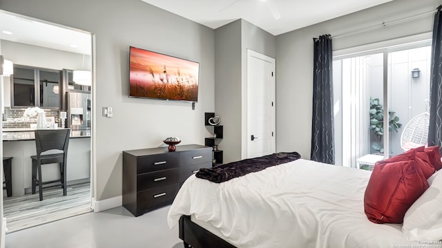 bedroom with multiple windows, ceiling fan, and stainless steel fridge with ice dispenser