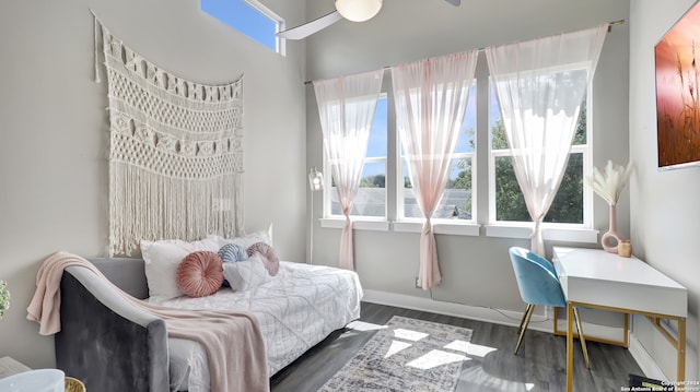 bedroom featuring dark wood-type flooring, multiple windows, and ceiling fan