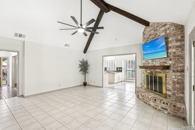 unfurnished living room with beamed ceiling, light tile patterned flooring, and a fireplace