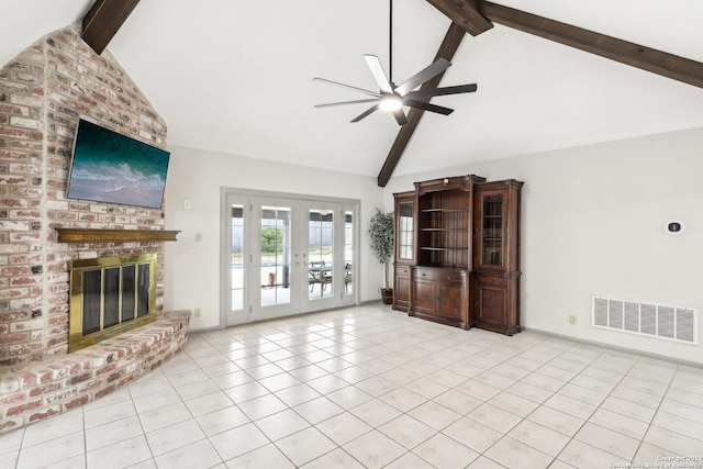 unfurnished living room with french doors, a brick fireplace, ceiling fan, light tile patterned floors, and lofted ceiling with beams