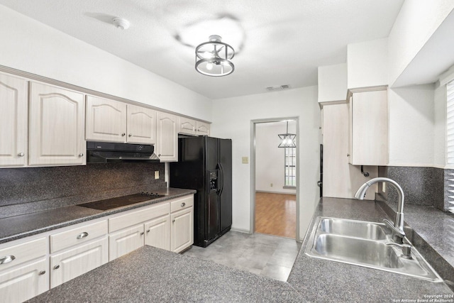 kitchen with black appliances, decorative backsplash, light wood-type flooring, and sink