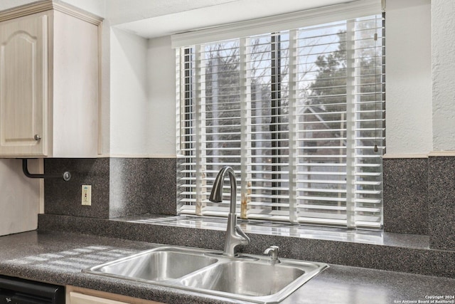 kitchen featuring backsplash, dishwashing machine, sink, and light brown cabinetry