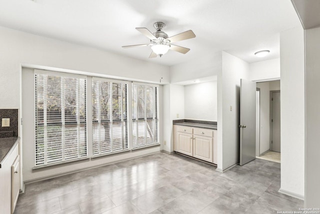 unfurnished dining area featuring ceiling fan