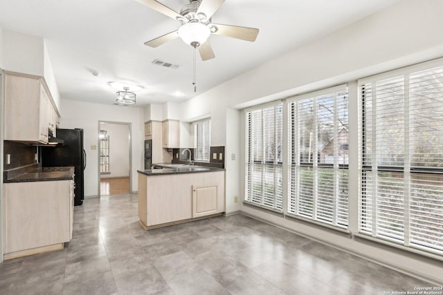 kitchen with ceiling fan, sink, black fridge, kitchen peninsula, and light brown cabinetry