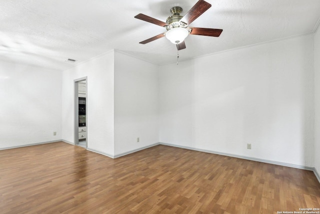 unfurnished room with hardwood / wood-style flooring, ceiling fan, crown molding, and a textured ceiling