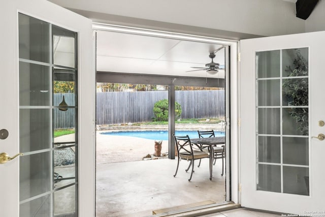 doorway with ceiling fan and concrete flooring