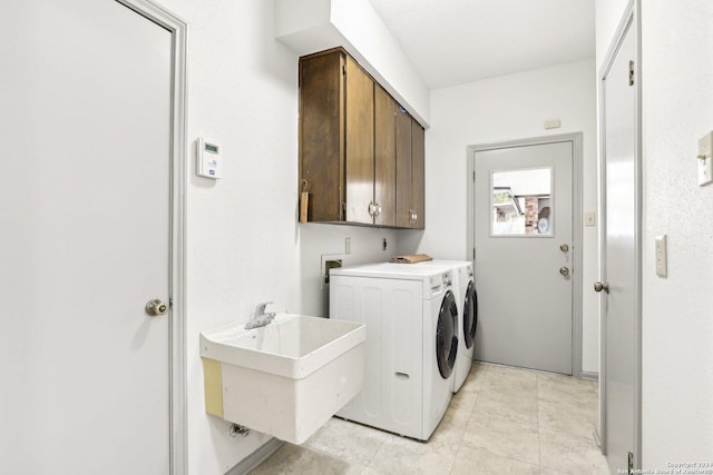 laundry area with cabinets, light tile patterned floors, washer and dryer, and sink