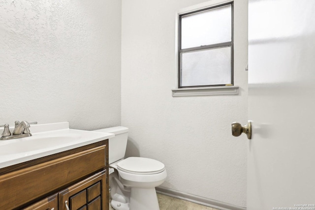 bathroom with tile patterned flooring, vanity, and toilet