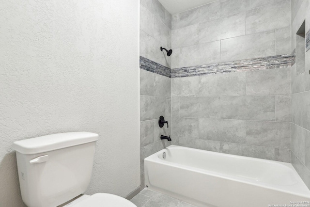 bathroom with tiled shower / bath combo and toilet