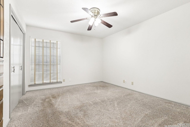 carpeted empty room featuring ceiling fan