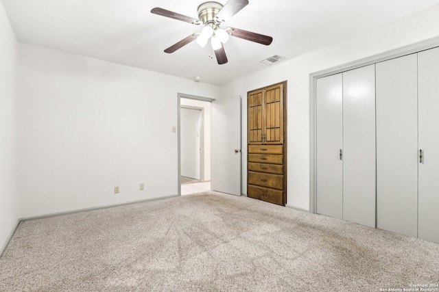 unfurnished bedroom with ceiling fan, light carpet, and a closet