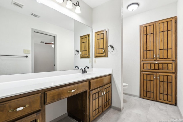 bathroom with tile patterned flooring, vanity, and toilet