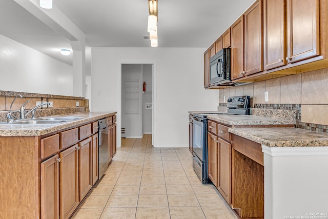 kitchen featuring hanging light fixtures, backsplash, sink, black appliances, and light tile patterned floors