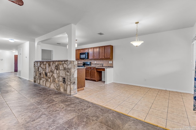 kitchen with light tile patterned floors, tasteful backsplash, black appliances, and decorative light fixtures