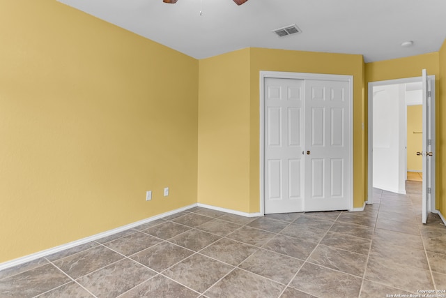 unfurnished bedroom with tile patterned floors, a closet, and ceiling fan