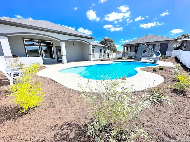 view of swimming pool featuring ceiling fan, a water slide, and a patio