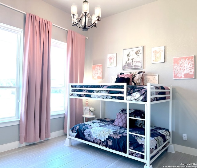 bedroom featuring hardwood / wood-style floors and a notable chandelier