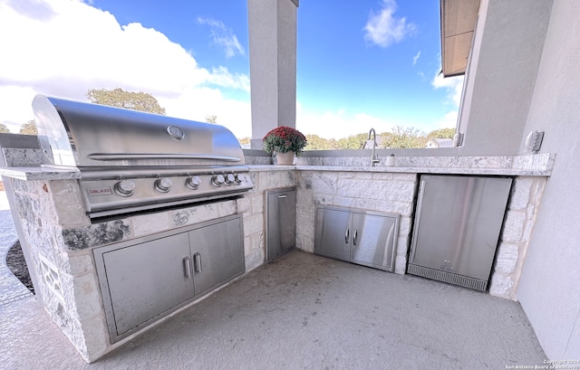 view of patio with grilling area, sink, and exterior kitchen