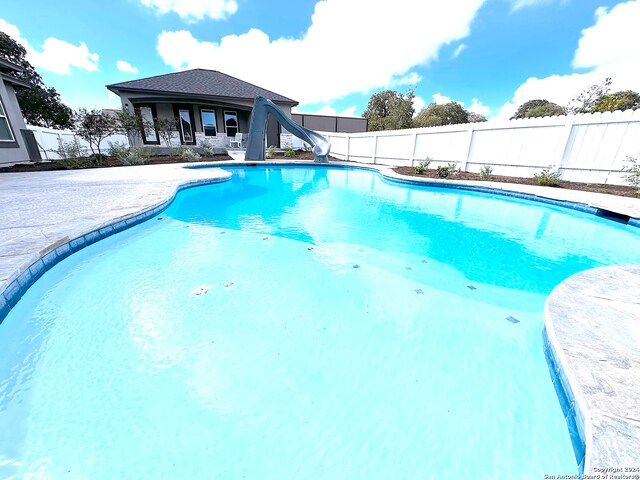 view of swimming pool with a water slide