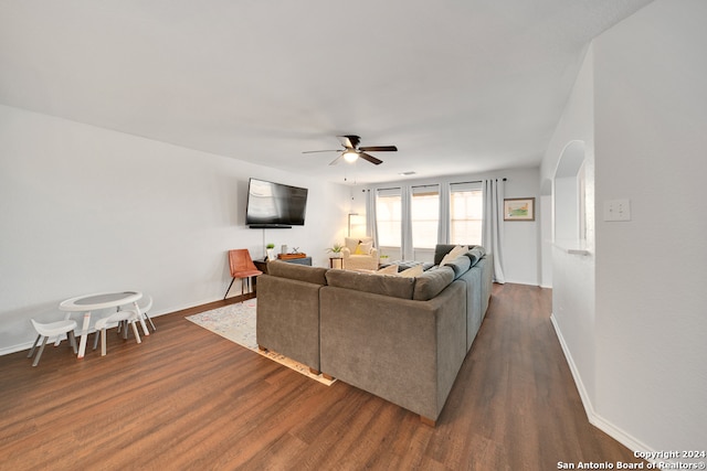 living room featuring ceiling fan and dark hardwood / wood-style floors