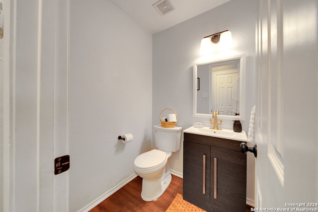 bathroom with vanity, toilet, and hardwood / wood-style flooring