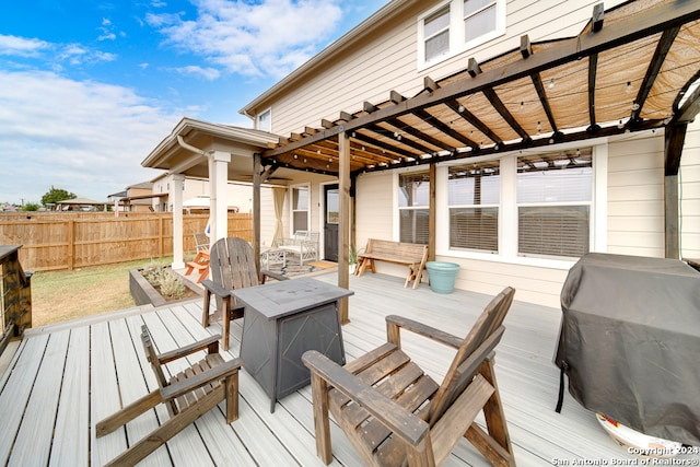 wooden deck featuring a grill and a pergola