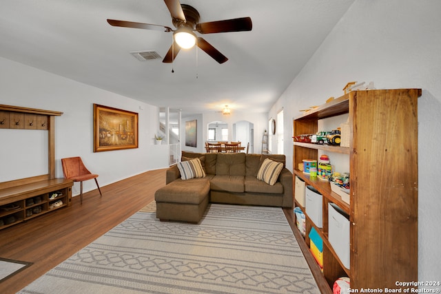 living room with ceiling fan, wood-type flooring, and lofted ceiling