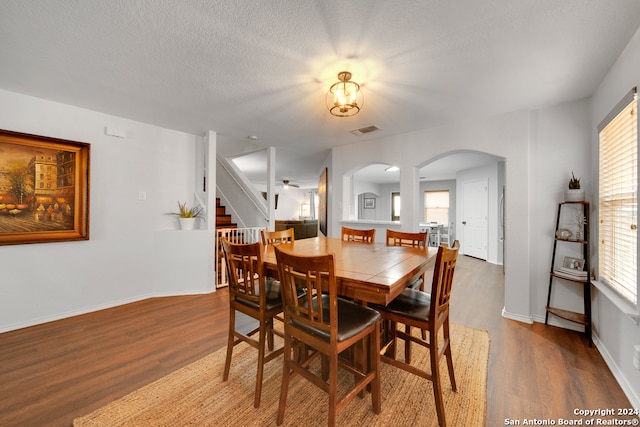 dining room featuring ceiling fan, hardwood / wood-style flooring, and a textured ceiling