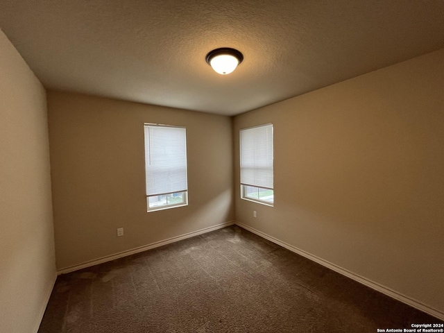 6607 Mia Way, San Antonio, TX 78233 - empty room with dark colored carpet, baseboards, and a textured ceiling