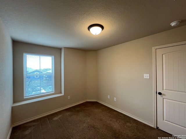 carpeted spare room with a textured ceiling