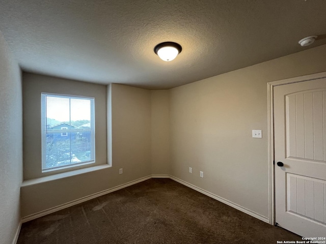 6607 Mia Way, San Antonio, TX 78233 - empty room featuring dark carpet, a smoke detector, a textured ceiling, and baseboards