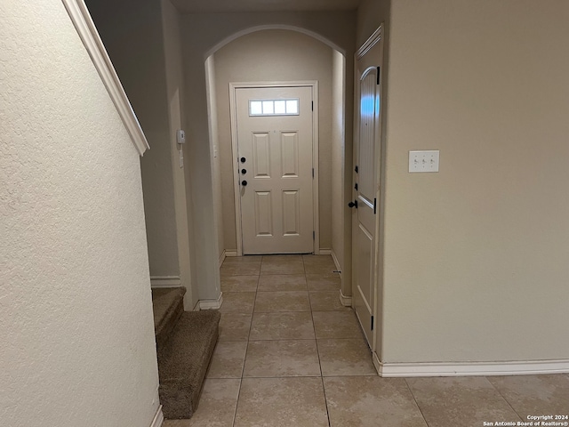 doorway to outside with light tile patterned floors