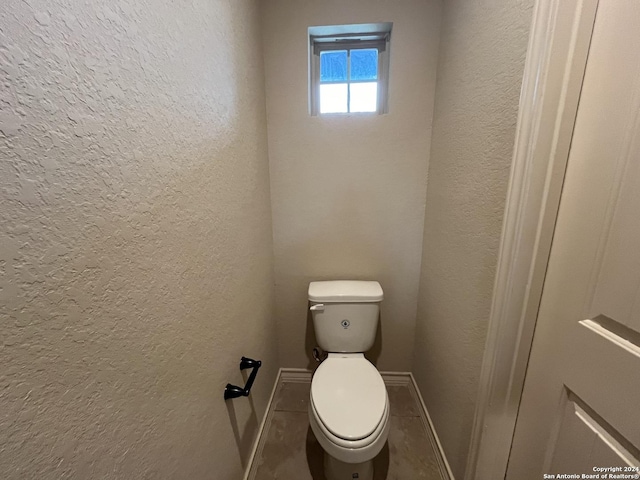 6607 Mia Way, San Antonio, TX 78233 - bathroom with a textured wall, baseboards, and toilet