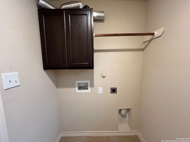 clothes washing area featuring tile patterned floors, electric dryer hookup, hookup for a washing machine, gas dryer hookup, and cabinets