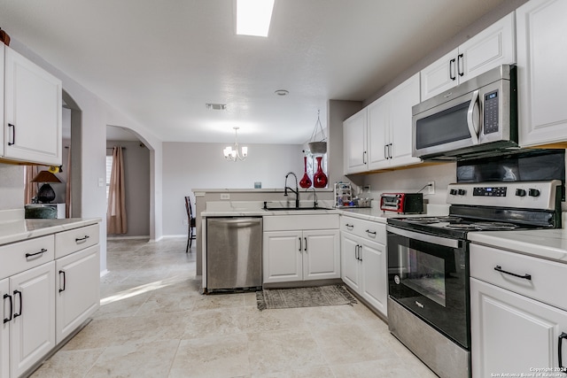 kitchen featuring hanging light fixtures, white cabinetry, kitchen peninsula, and stainless steel appliances