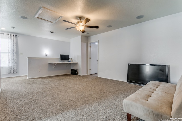 living room with a textured ceiling, carpet floors, and ceiling fan