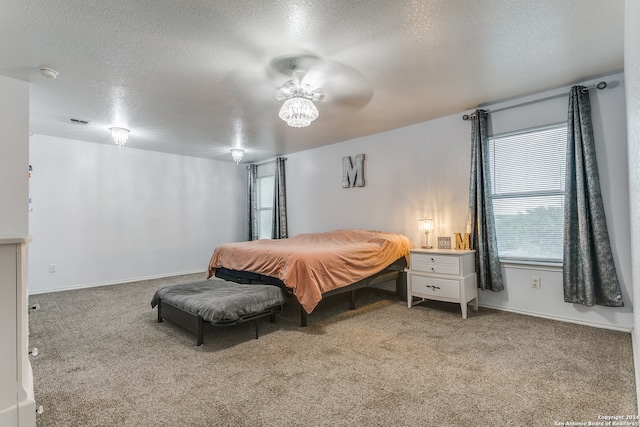 carpeted bedroom with a textured ceiling and ceiling fan