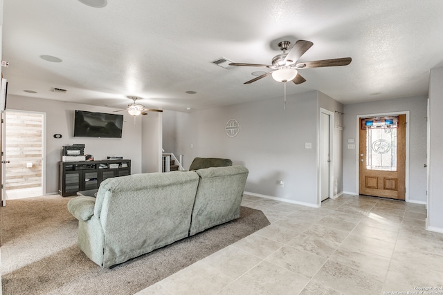 living room featuring ceiling fan and a textured ceiling